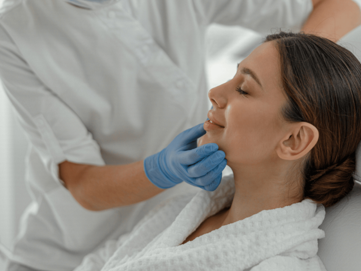 a woman having her skin examined by the doctor