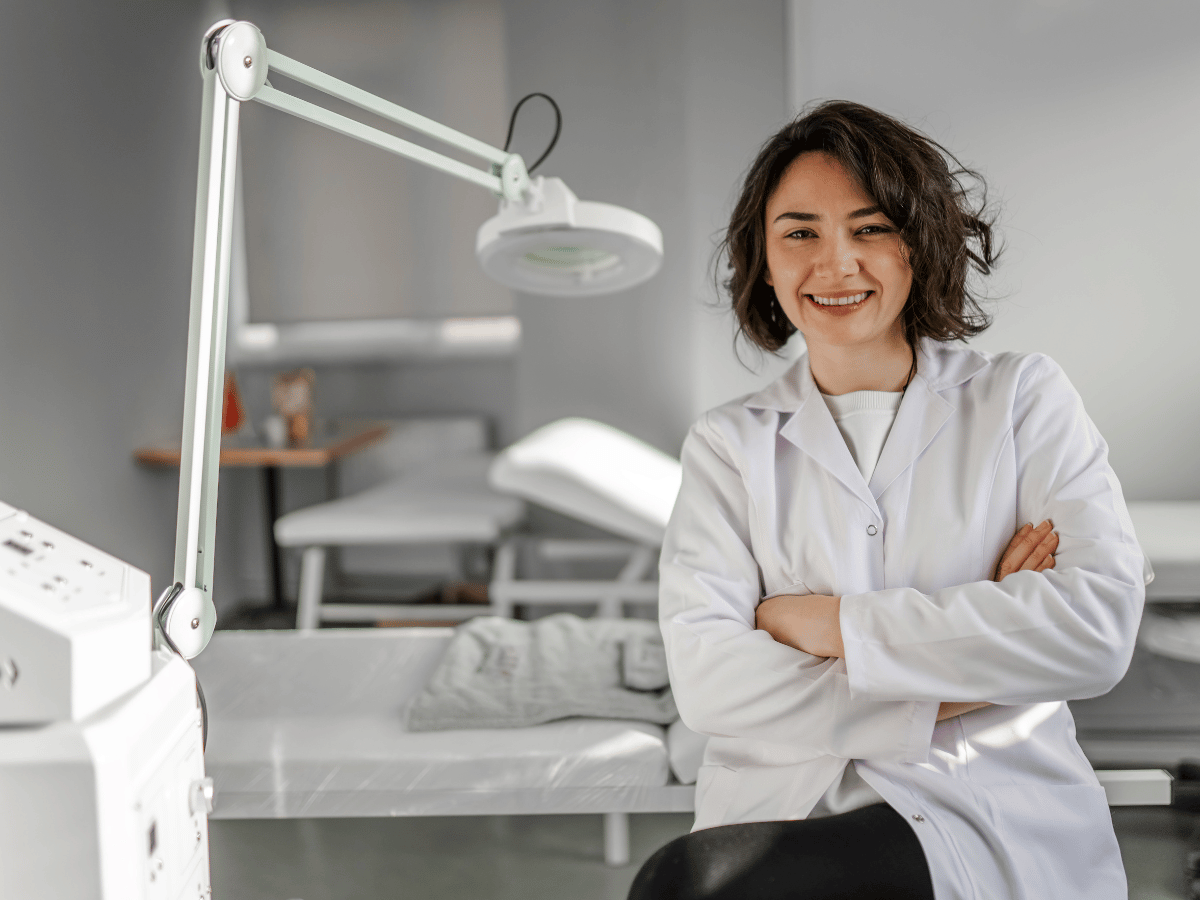 Provider in a dermatology office in front of a consultation chair.